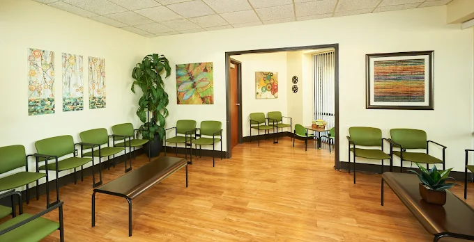Green chairs and colorful artwork in waiting area