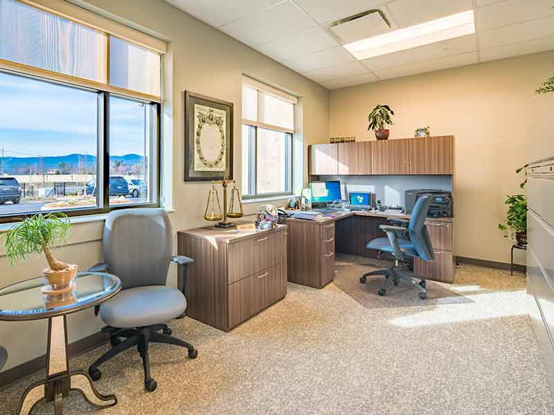 Private counseling and administrative office with desk and windows at recovery center