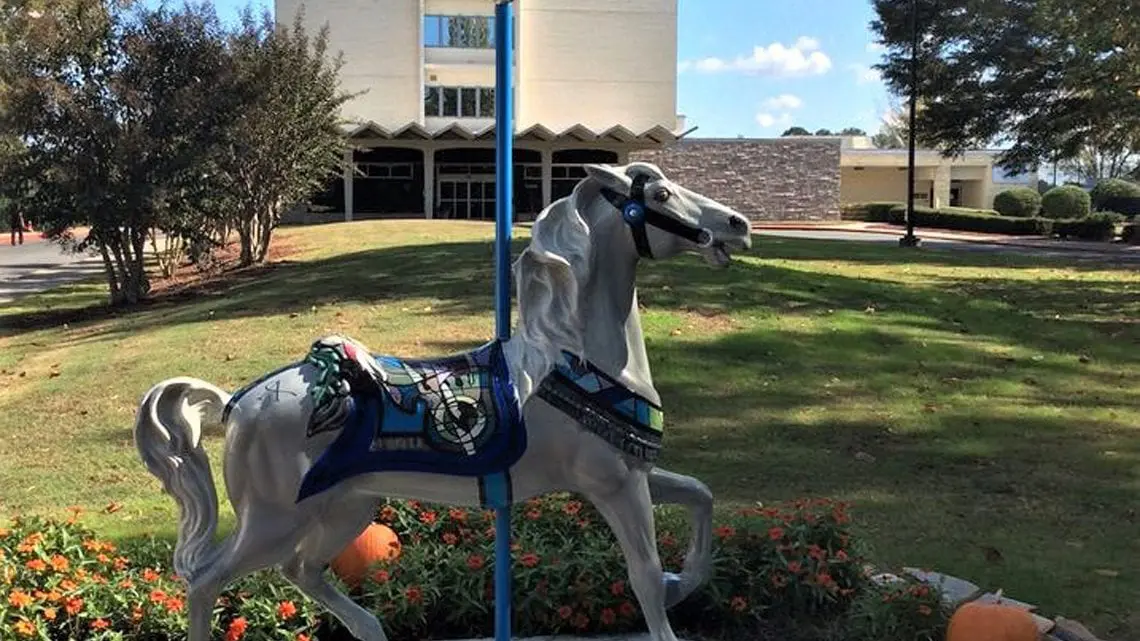 Decorative carousel horse on landscaped facility grounds