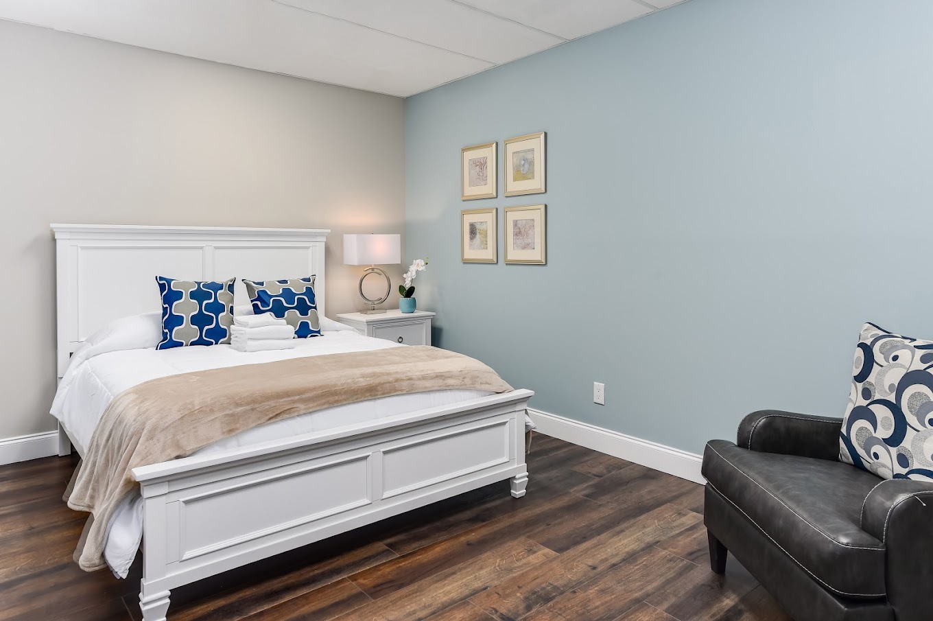 Bedroom with white bed, armchair, and soft lighting