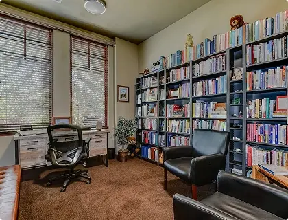 Library with bookshelves, desk, and seating