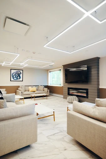 Bright lounge with modern ceiling lights and fireplace feature wall