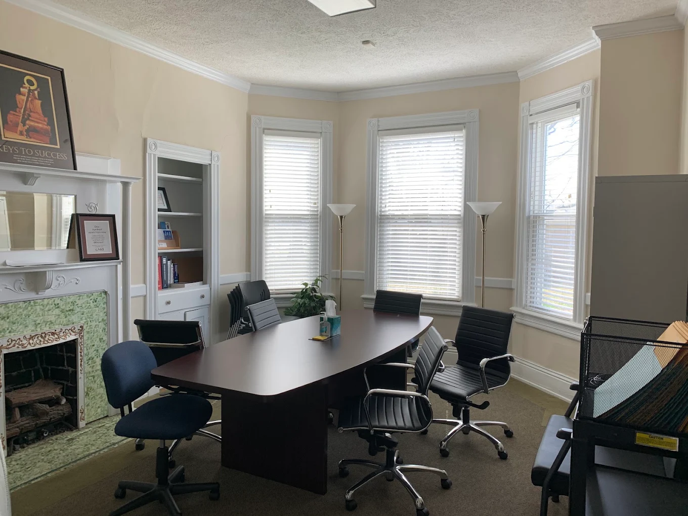 Meeting room with table, chairs, fireplace, and windows