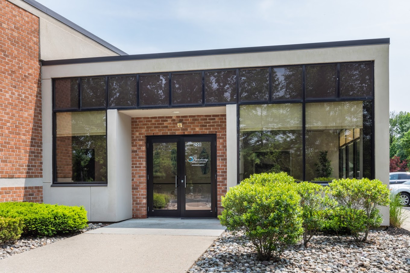 Entrance walkway with windows and a brick facade.