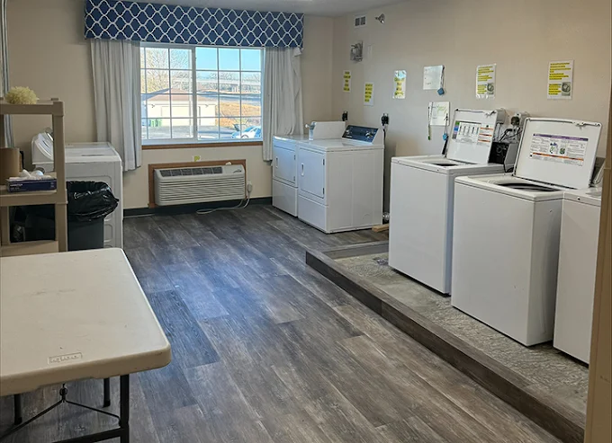 Laundry room with washers, dryers, and folding table