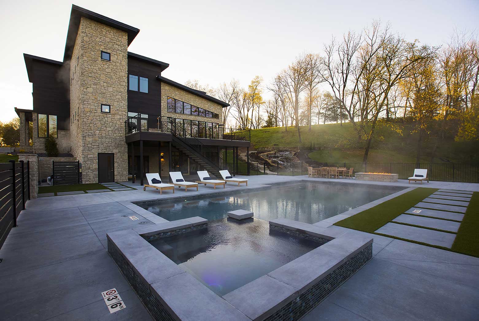 Outdoor pool with lounge chairs and modern facility backdrop