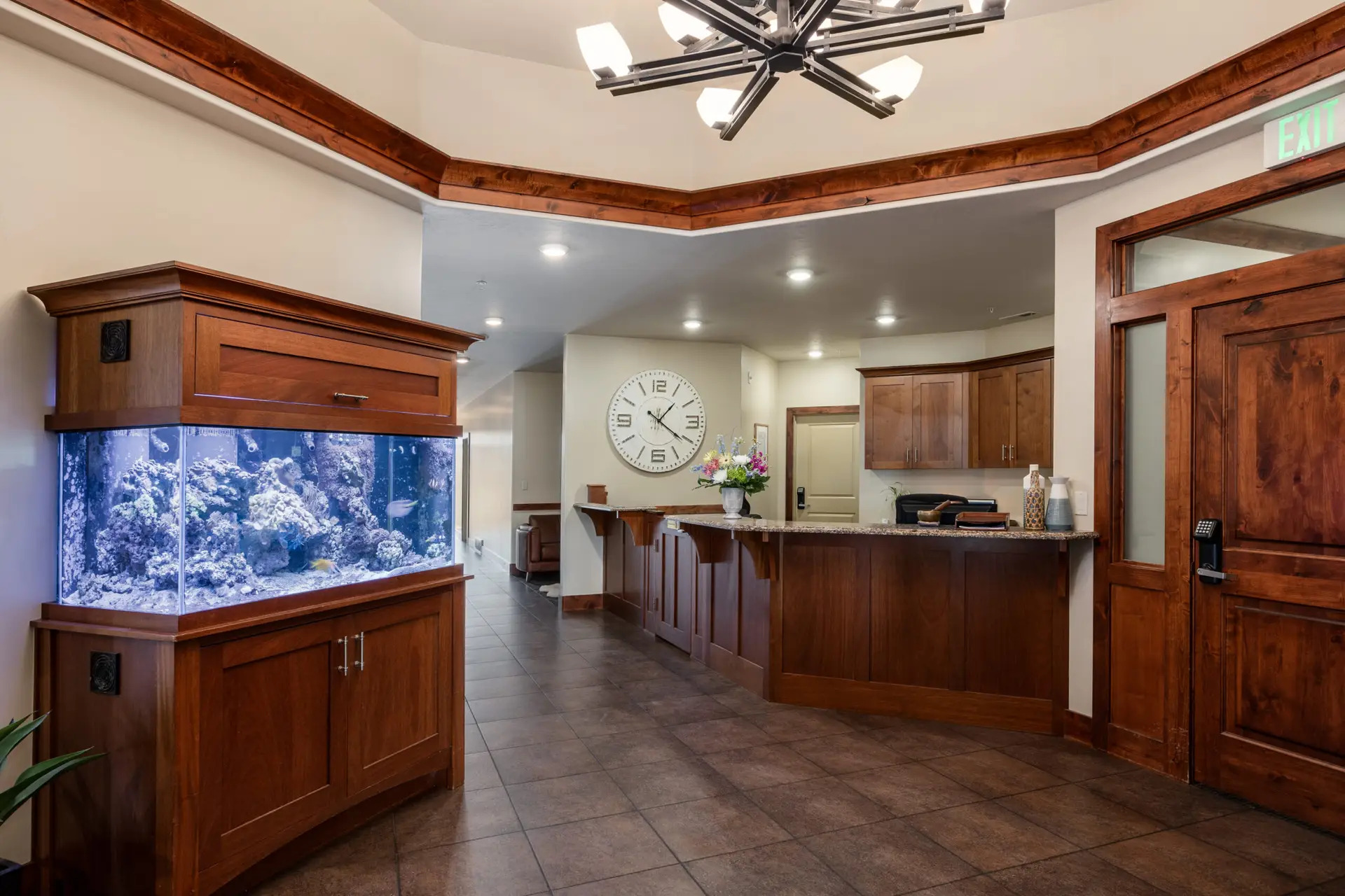 Reception desk with large wall clock and aquarium nearby