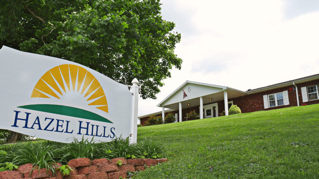 Hazel Hills sign in front of brick rehab center with white pillars