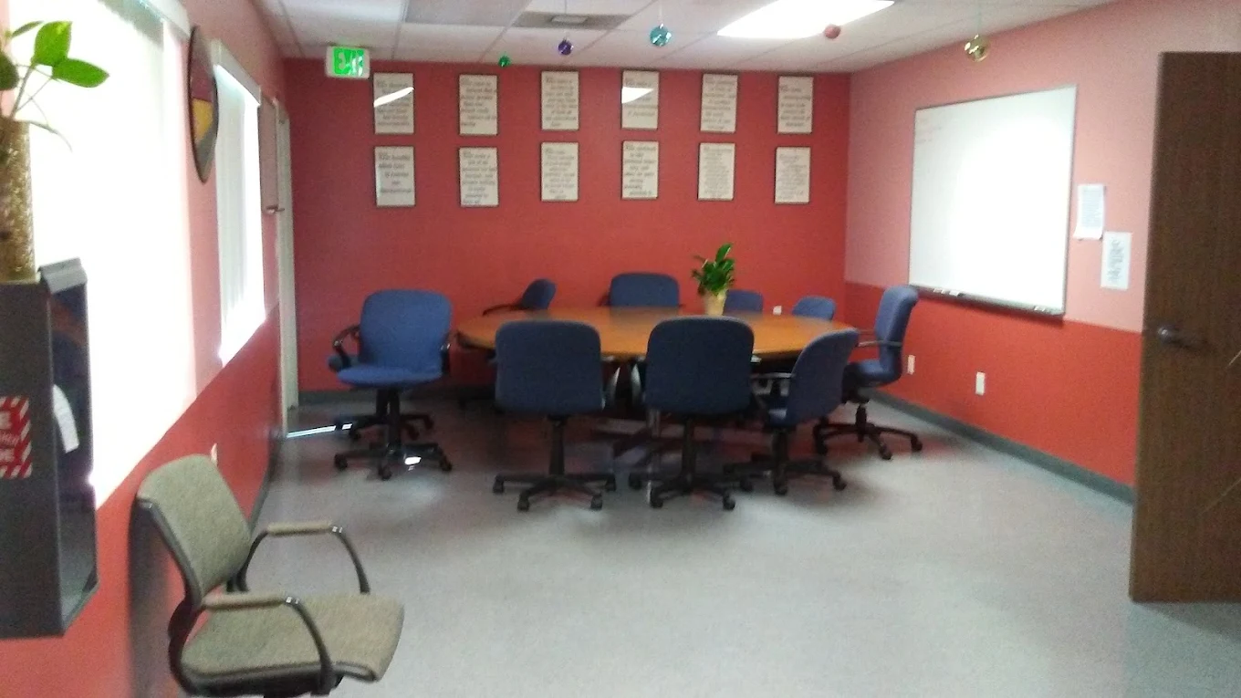 Conference room with oval table and blue chairs in rehab center