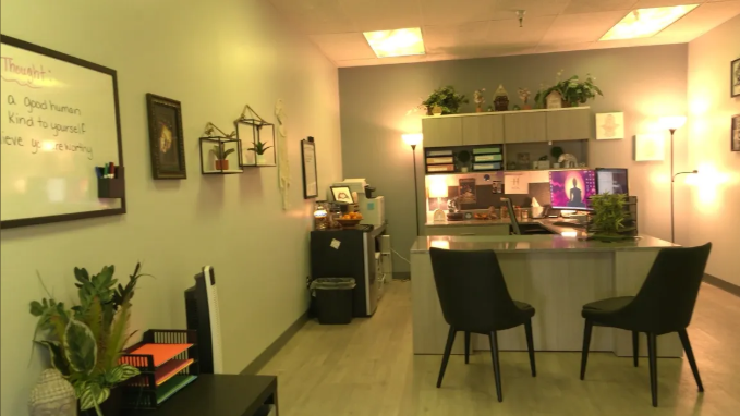 Therapist office with desk, chairs, and soft lighting