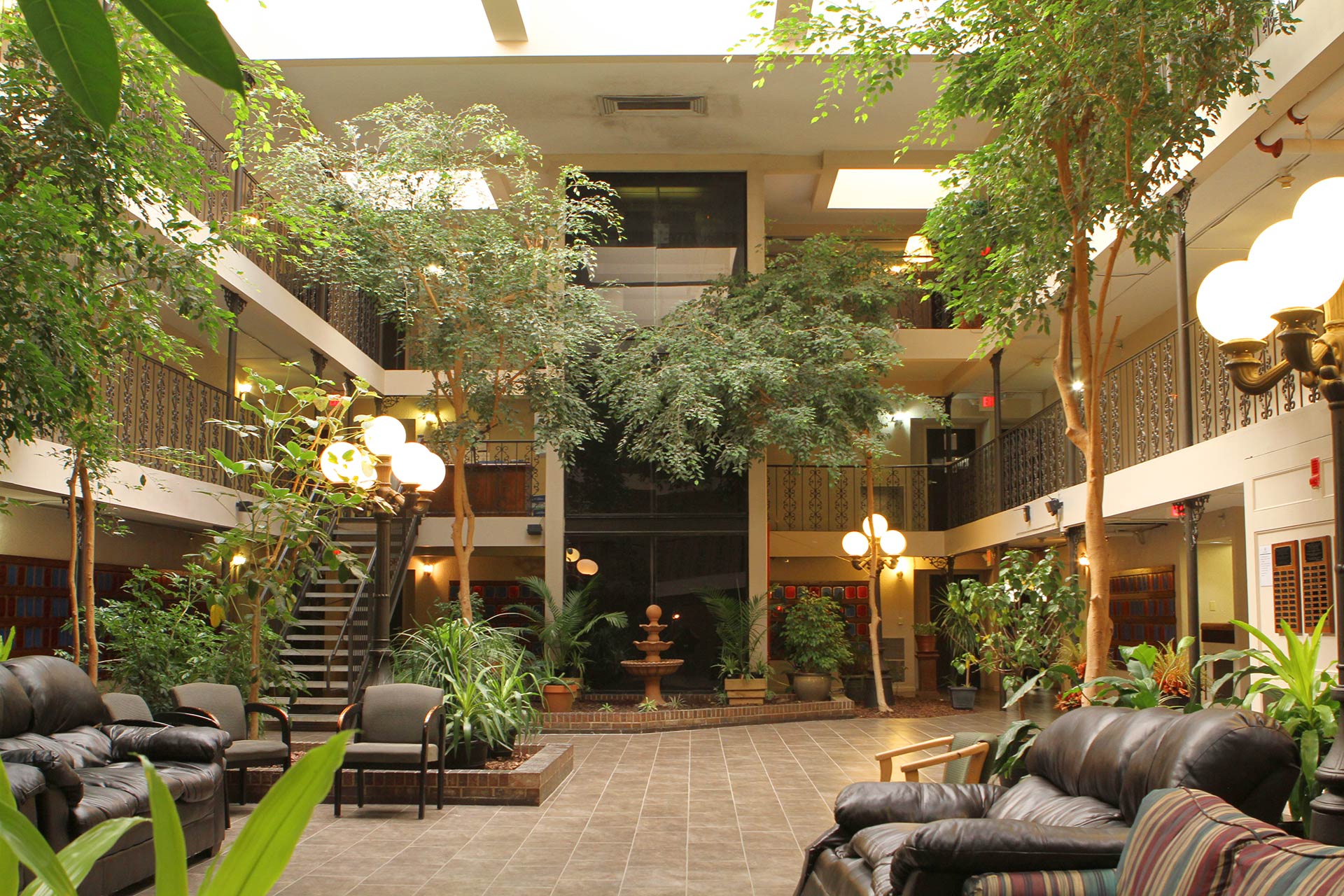 Open atrium with trees, fountain, and seating