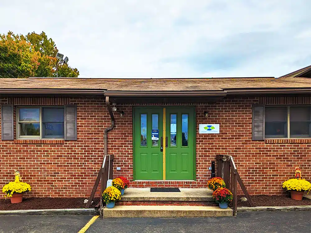 Brick clinic exterior with green doors and entry steps