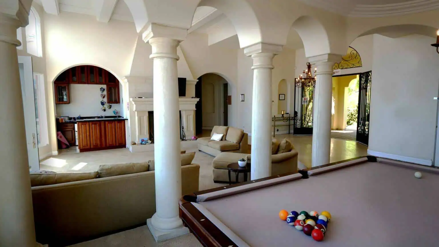 Billiards area with pool table, columns, and adjoining lounge