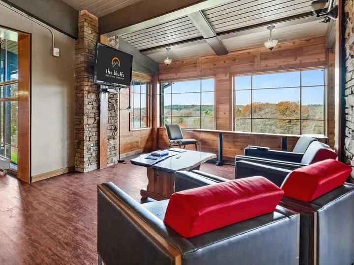 Lounge with leather seating, game table, and large windows
