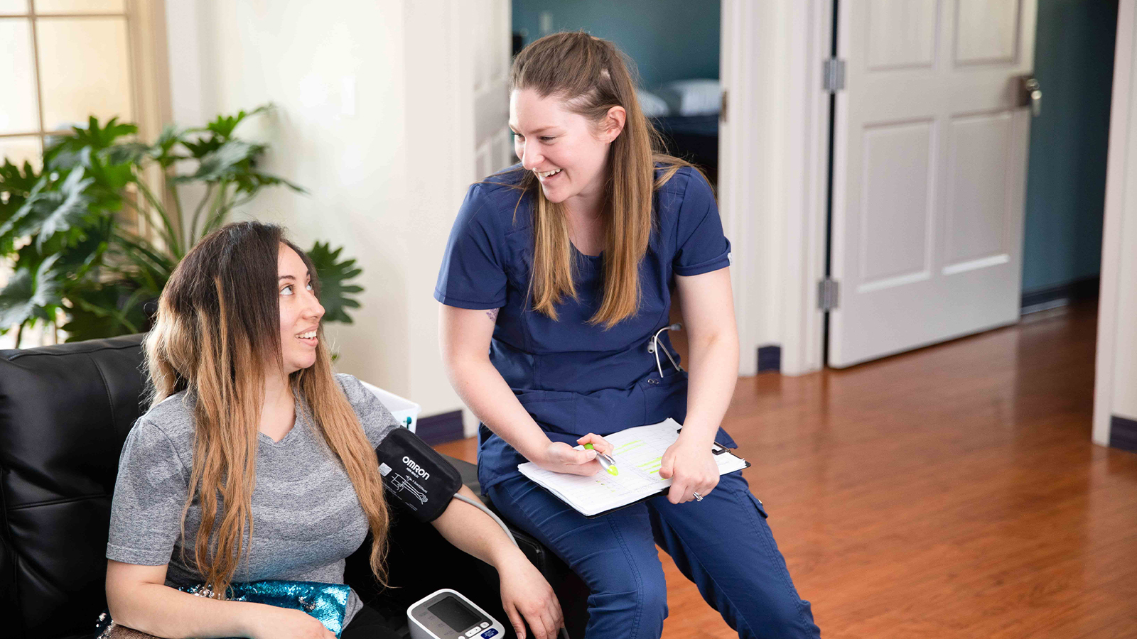 Nurse checks blood pressure of patient.