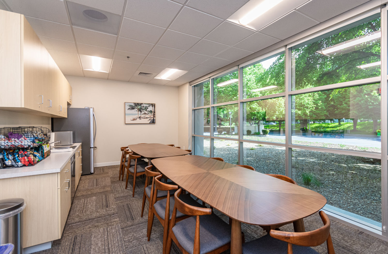 Dining and kitchenette area with tables and large windows