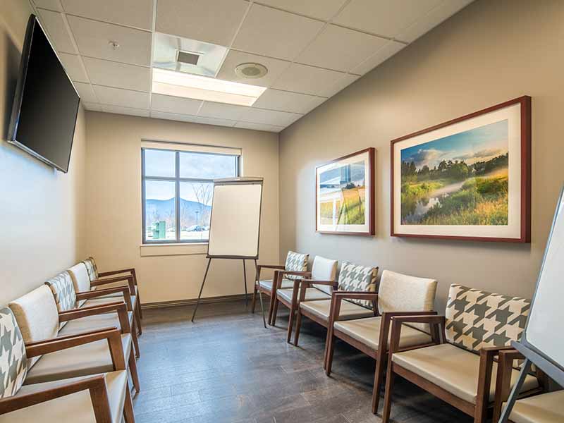 Small therapy and discussion room with chairs and presentation easels at recovery center