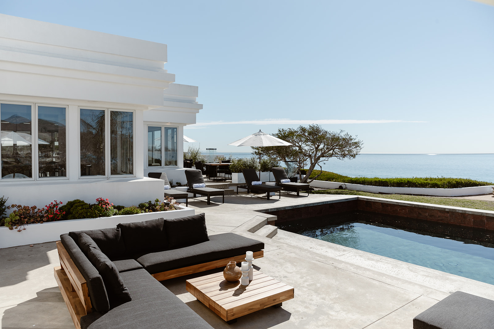  Oceanfront patio with lounge seating, umbrellas, and a private pool.