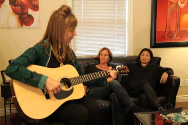 Woman playing guitar in a casual group session