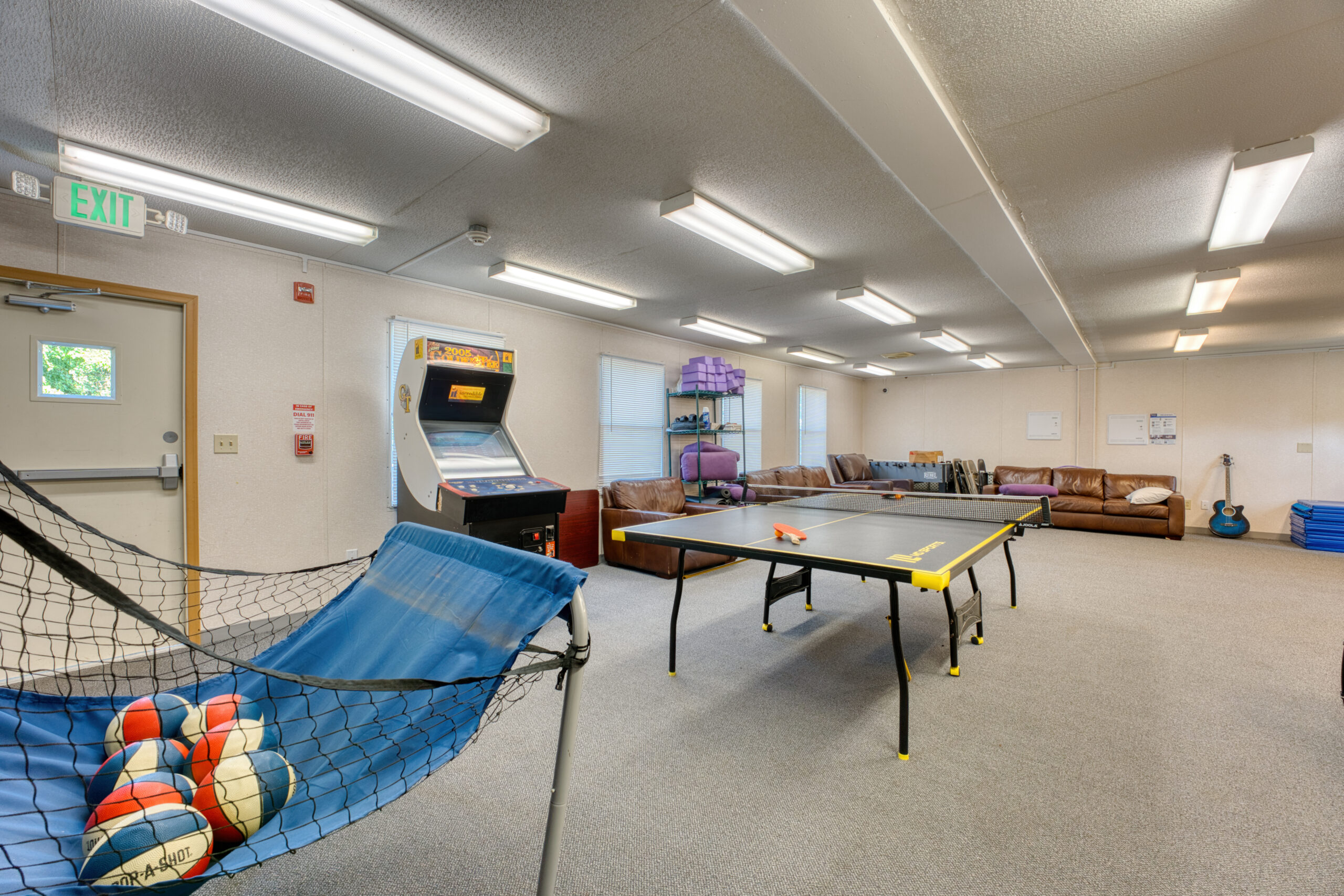 Recreation room with ping pong, arcade, and couches.