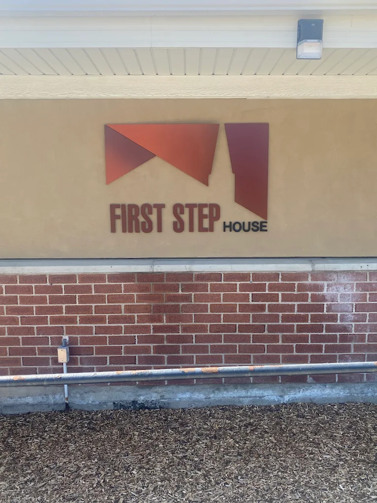 First Step House logo on brick and tan building wall