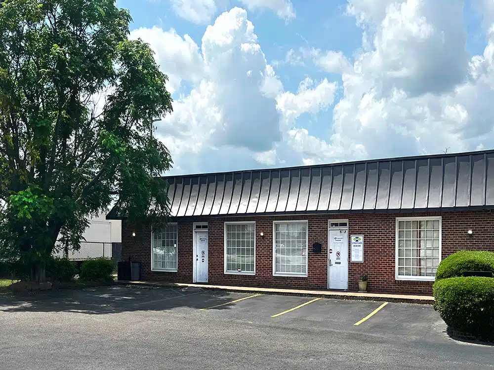 Brick clinic building with parking lot and trees