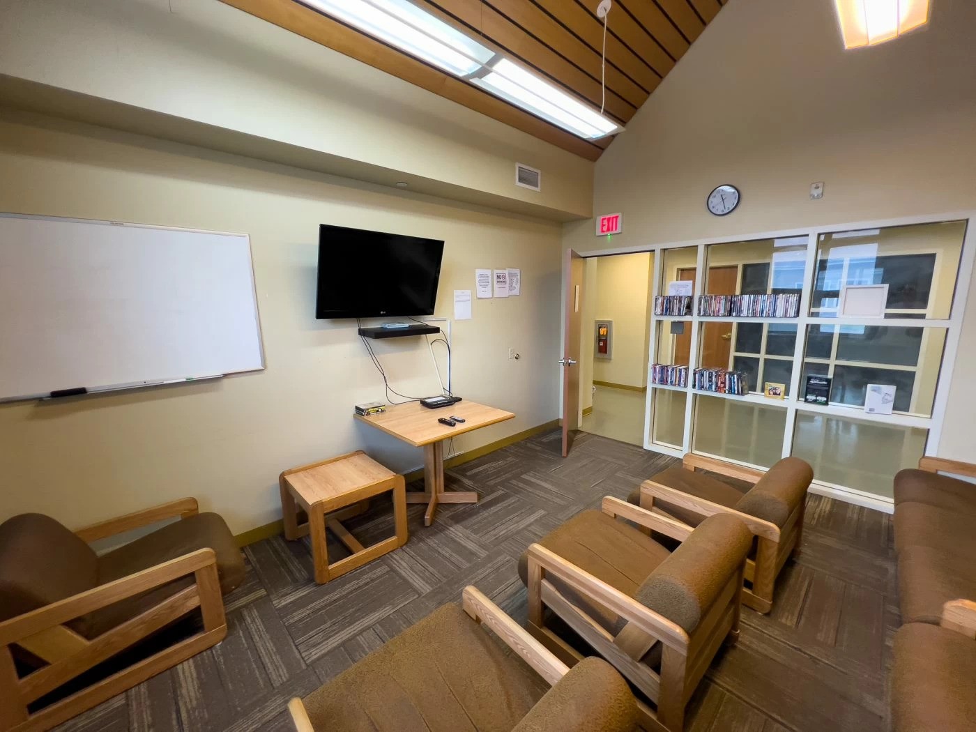 Room with TV, chairs, and whiteboard for groups