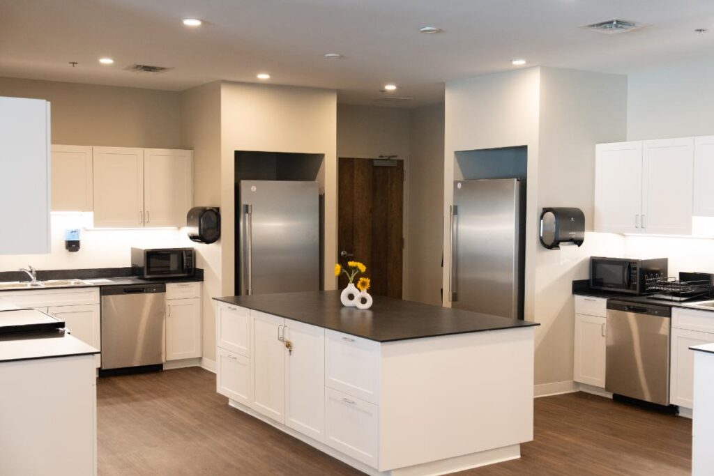 Spacious modern kitchen with stainless steel appliances, two refrigerators, and a central island