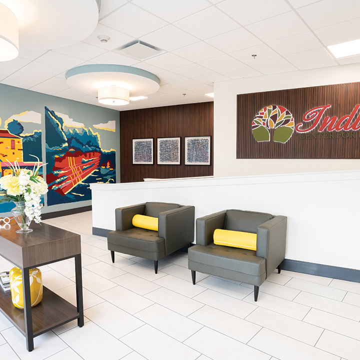 Bright waiting area with colorful mural, artwork and chairs.