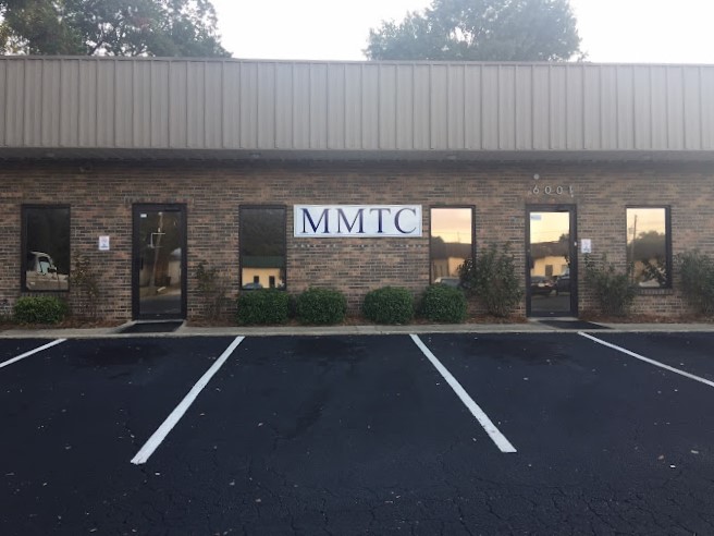 The exterior of a brick rehab facility with a sign reading "MMTC."