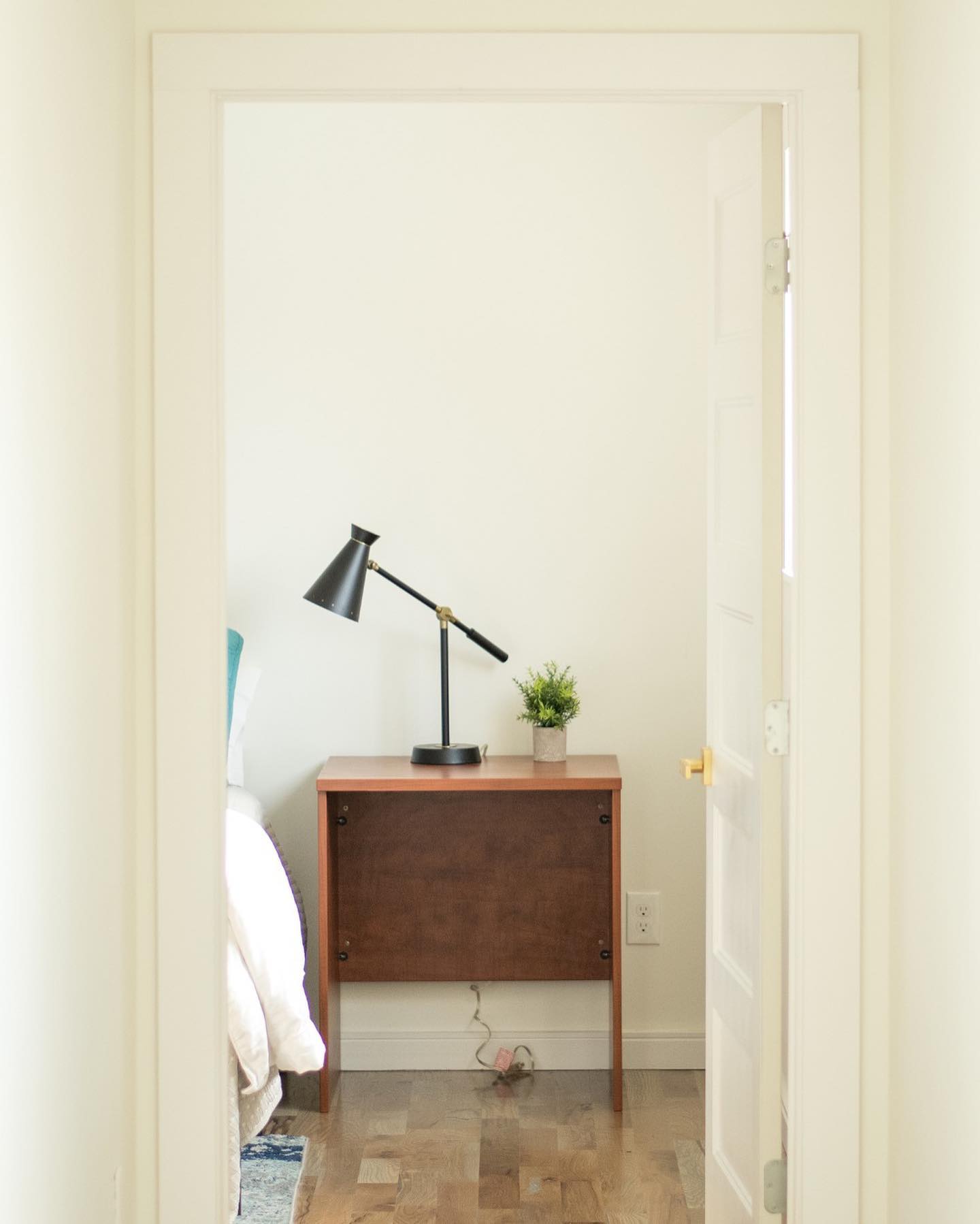 Bedroom view with desk, lamp, and simple decor