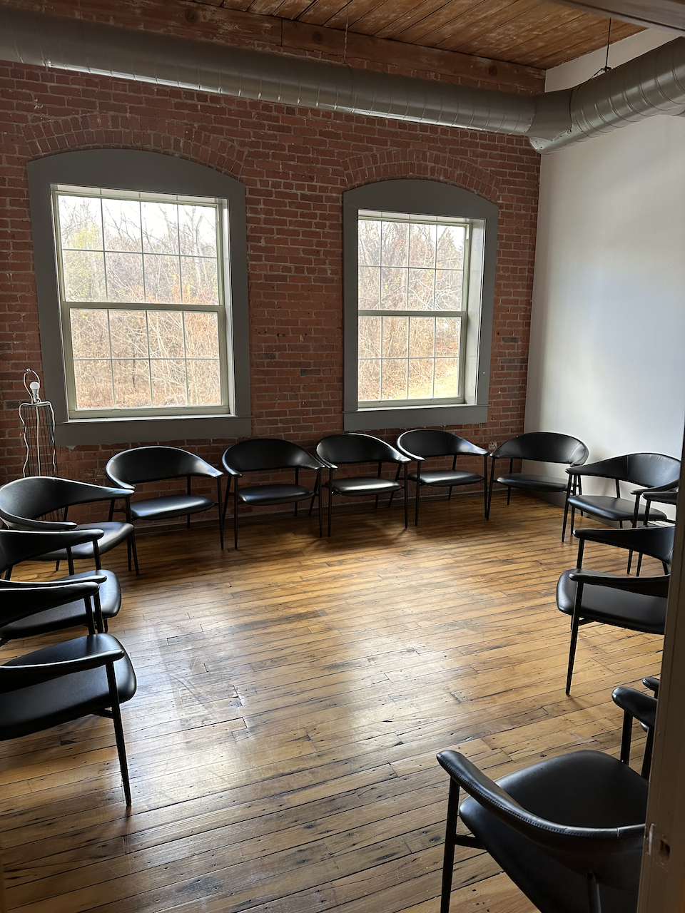 Group therapy room with black chairs arranged in a circle