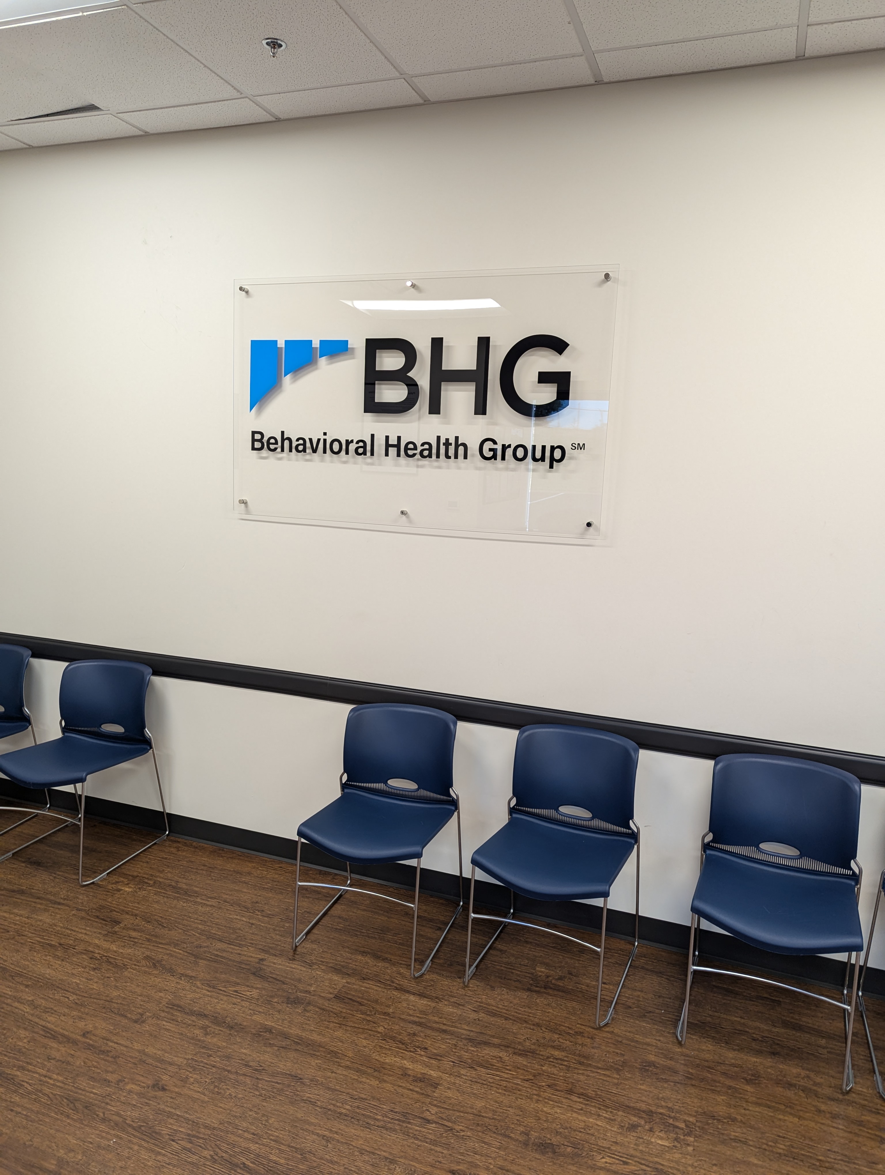 Behavioral Health Group wall sign above waiting room chairs