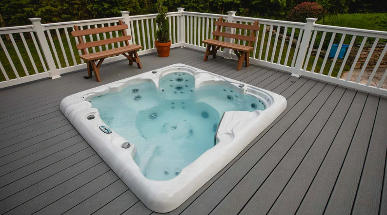 Outdoor hot tub on deck with white railings and bench seating