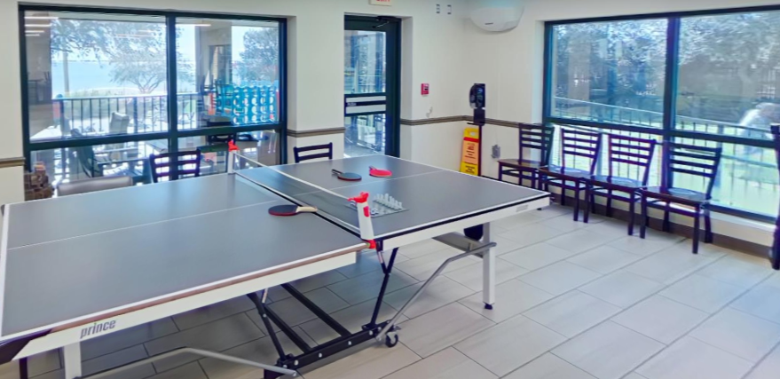 Ping pong table near large windows and seating area