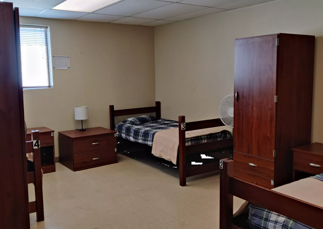 Shared bedroom with four single beds and wooden furniture