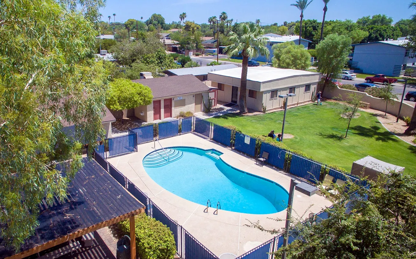 Fenced outdoor pool with lounge chairs and green lawn