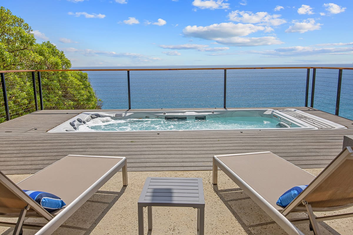 Hot tub on balcony with ocean views and outdoor seating