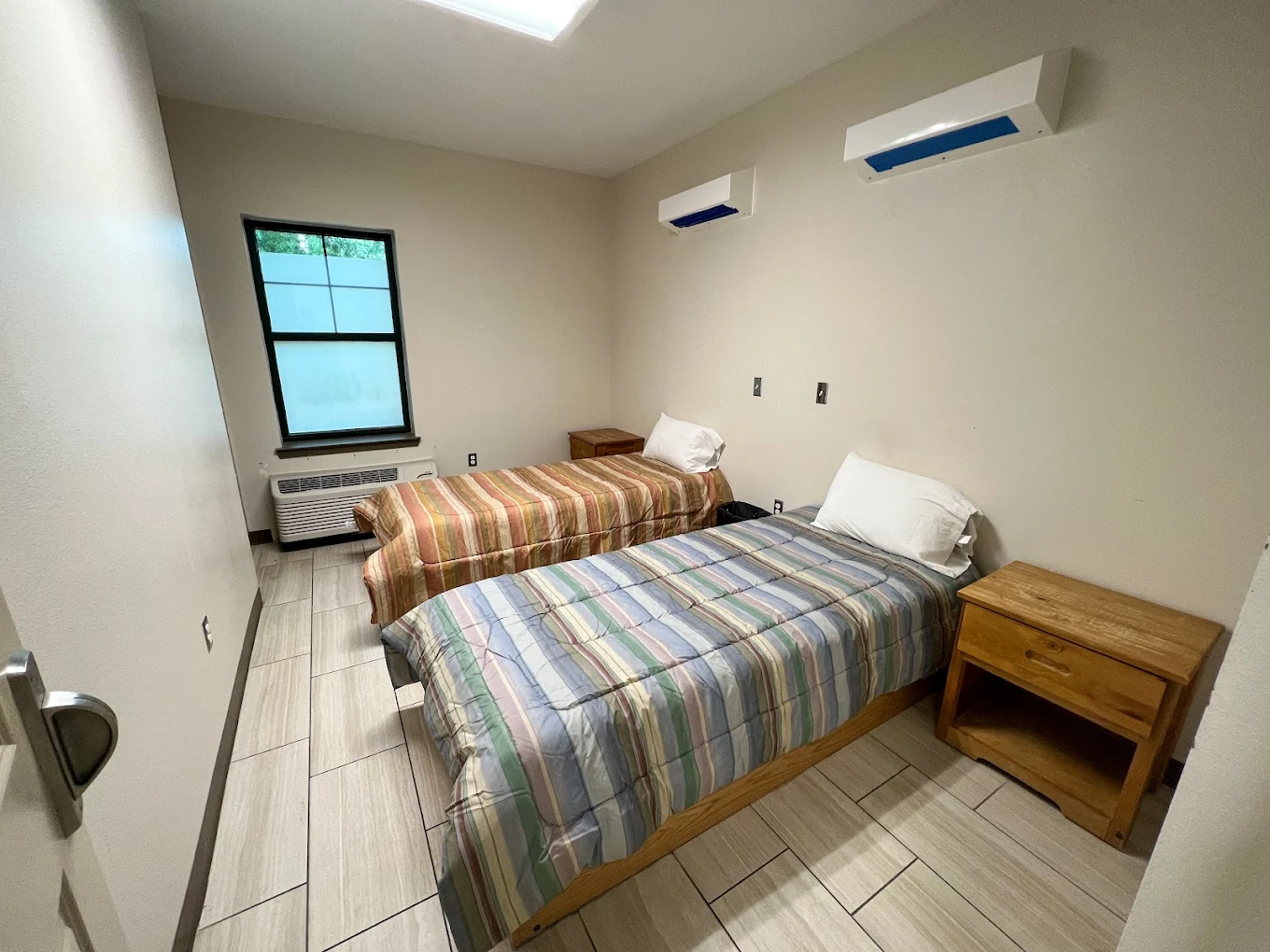 Room with two single beds and wood nightstands