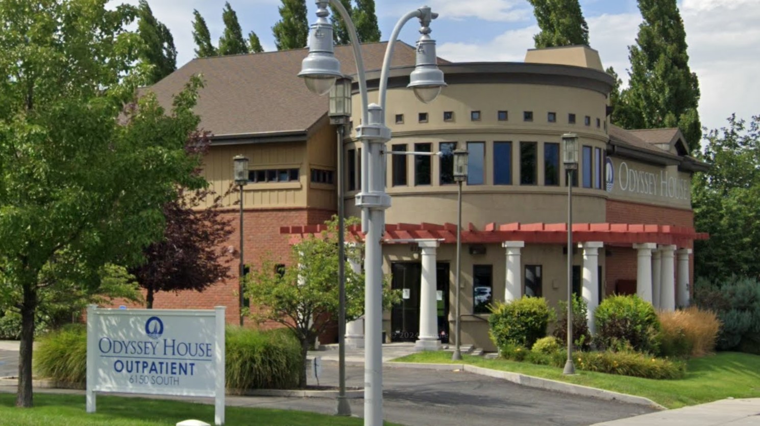 A welcoming entrance to Odyssey House Outpatient facility with greenery and a modern design.