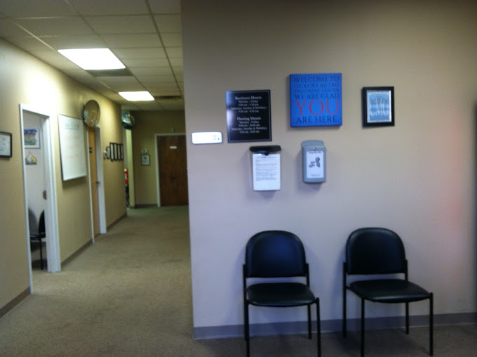 A waiting area with black chairs and informational signs on the wall