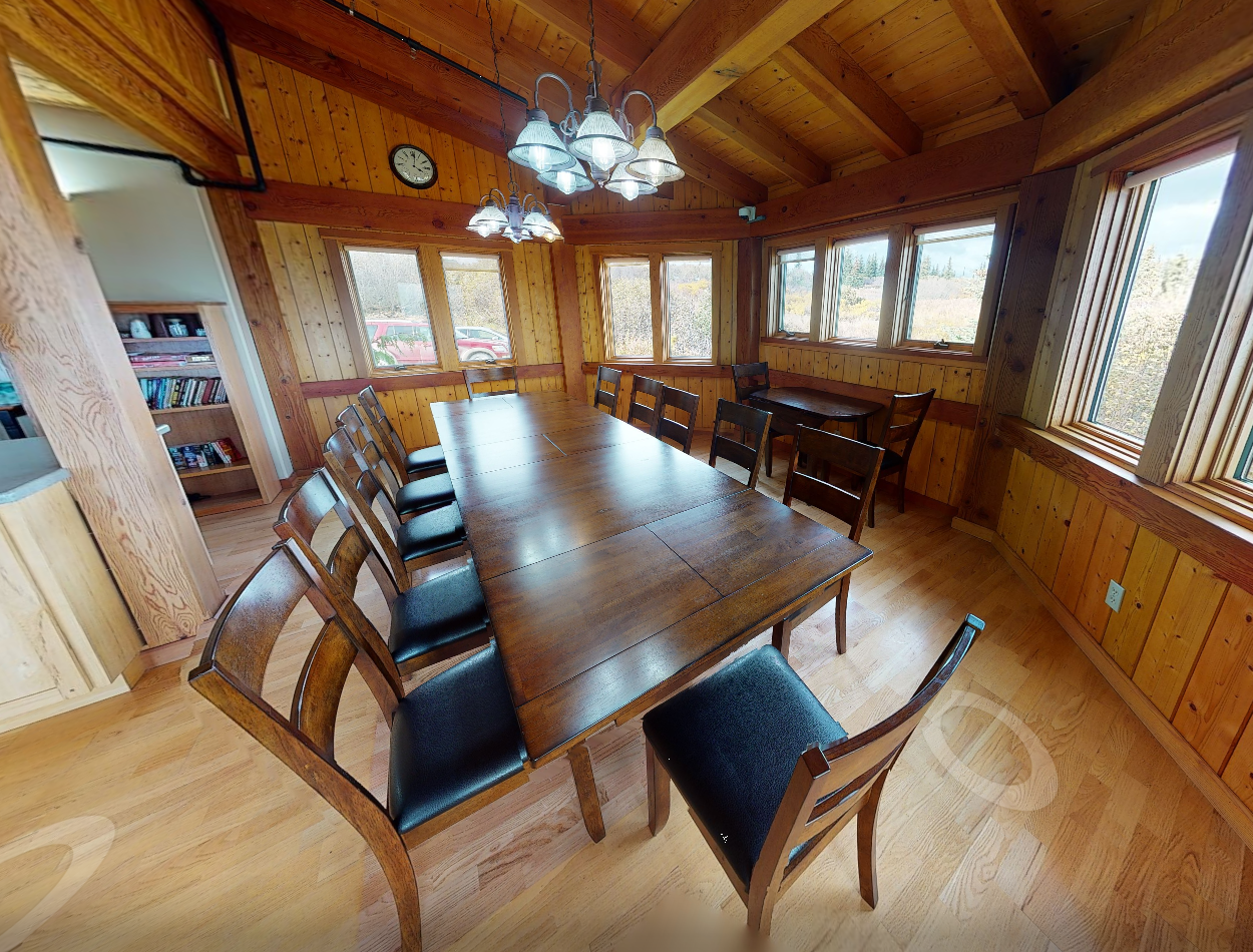 Communal dining room with long tables and natural light