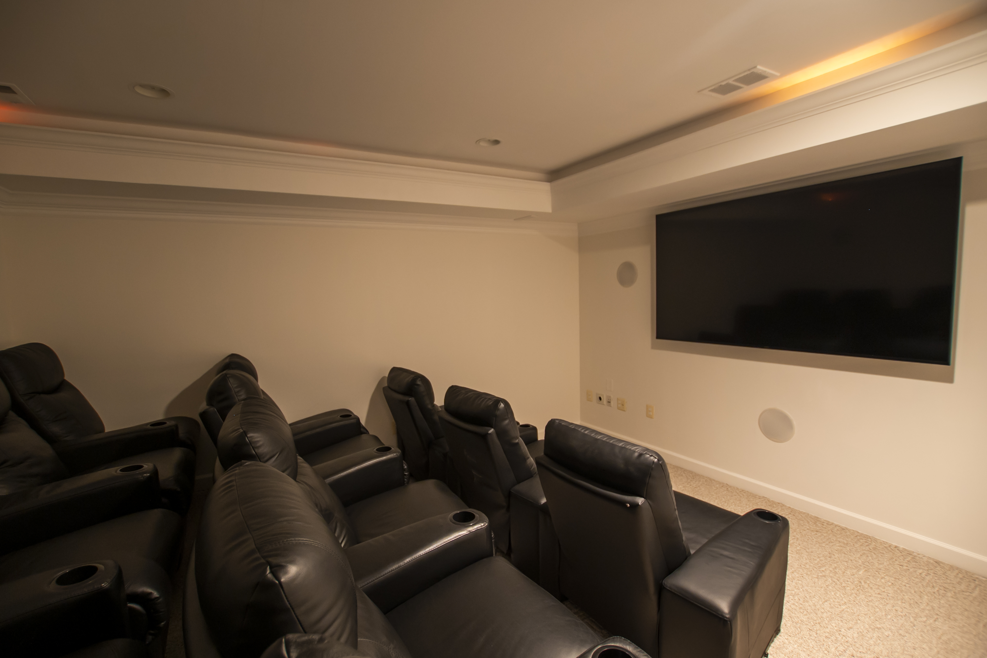 Home theater with leather recliners and TV.