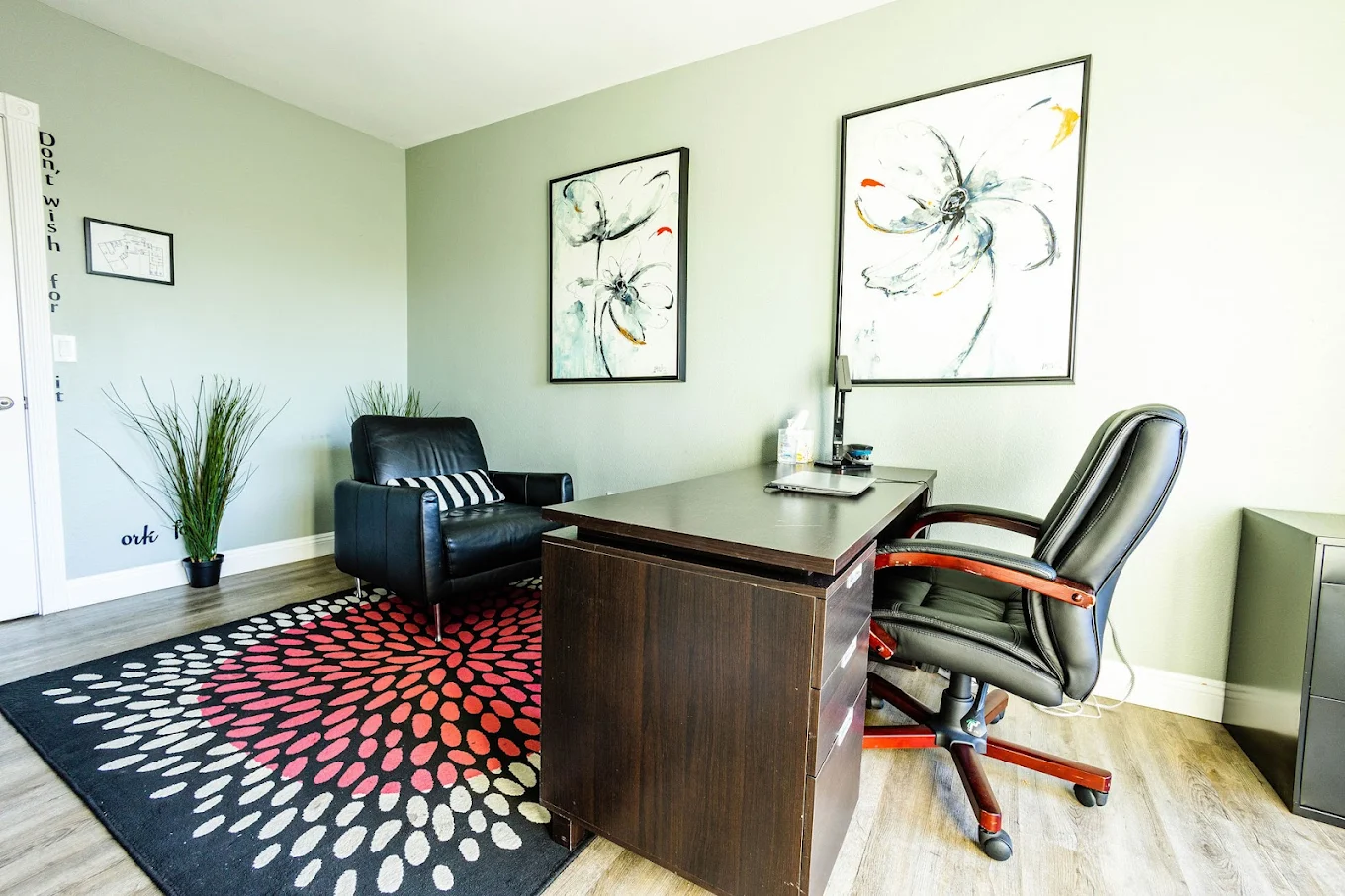 Therapy office with desk, chairs, and abstract art