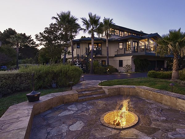 Treatment center exterior with landscaped patio and fire pit area at dusk