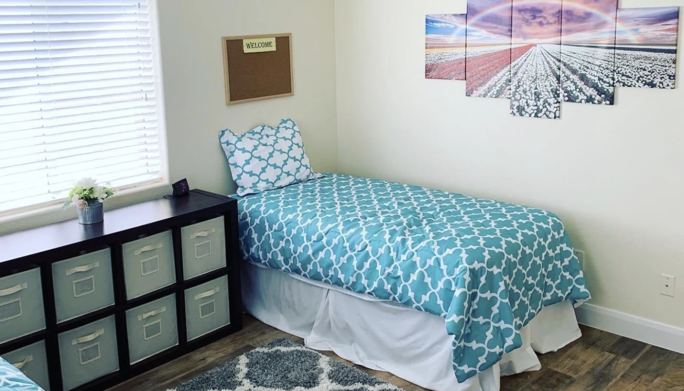 Bright bedroom with teal bedding and wall art