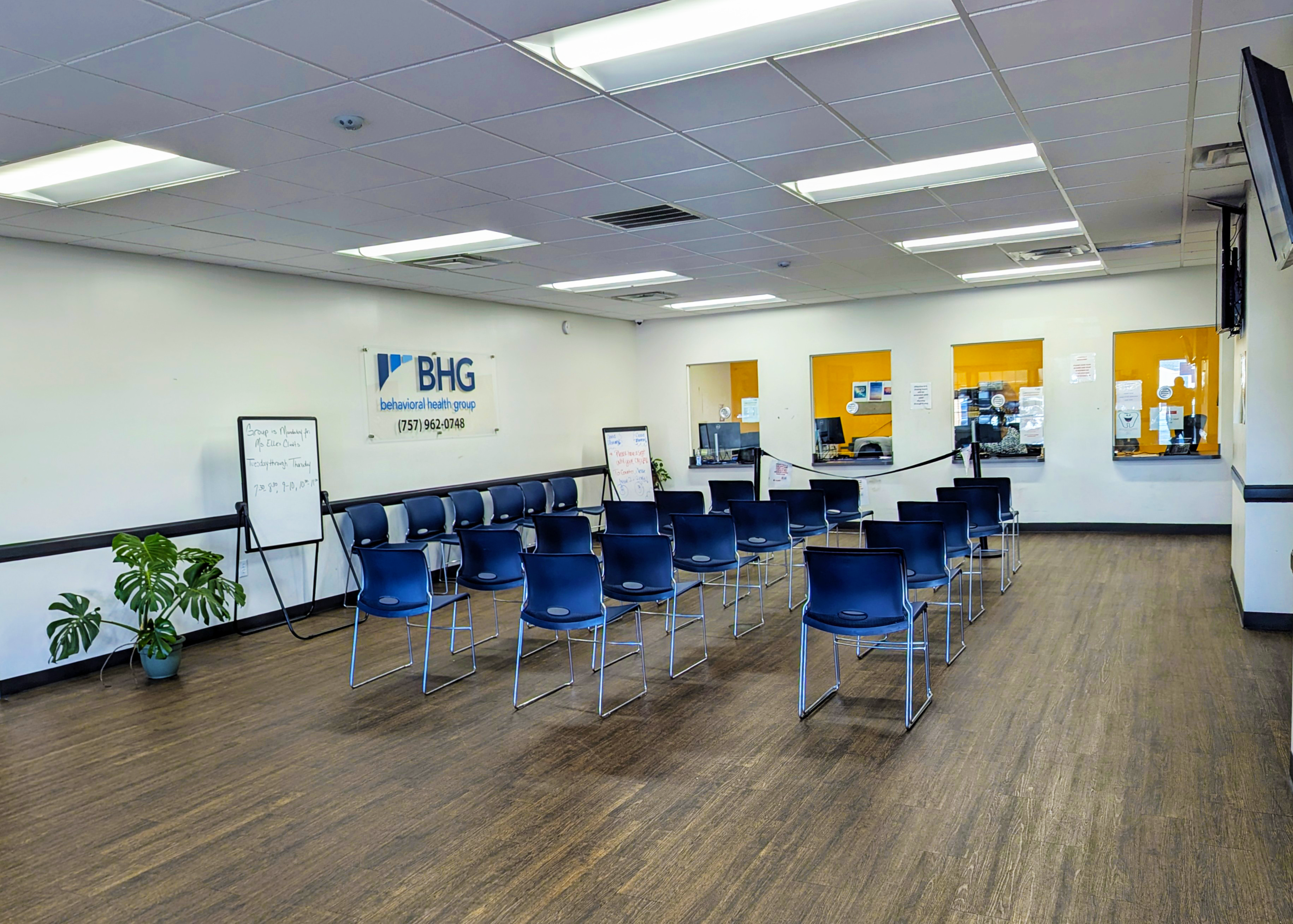 Spacious waiting room with chairs and patient check-in windows