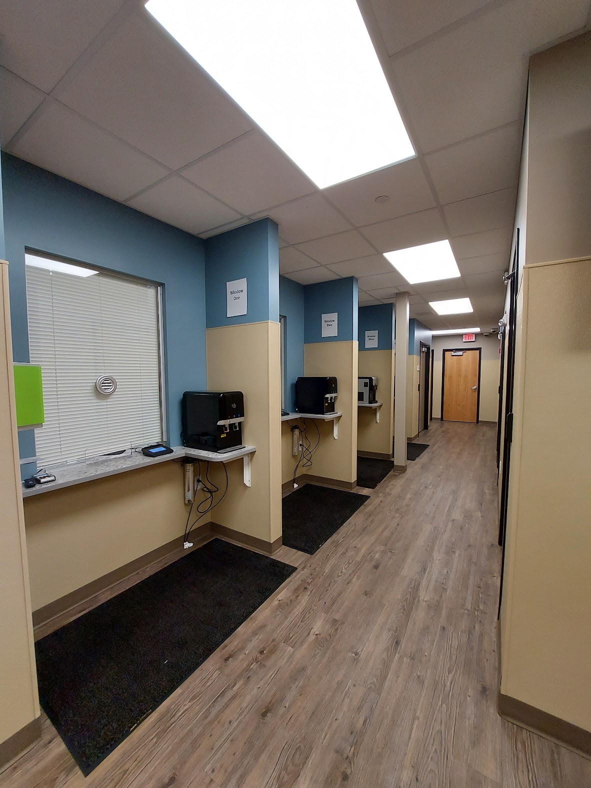 Row of dosing windows in hallway with computers