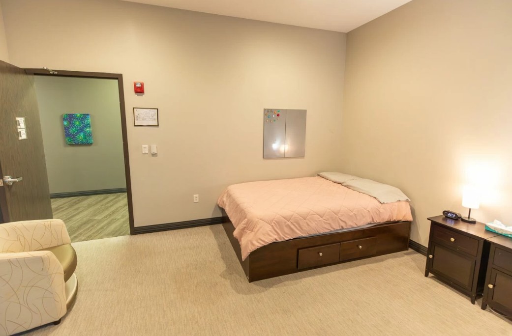 Private bedroom with bed, nightstand, and chair