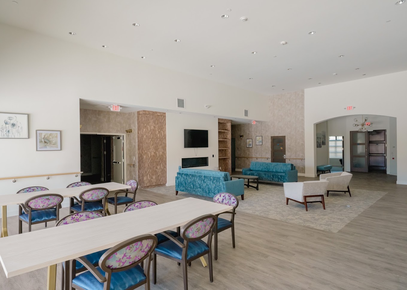 Open common area with dining tables, couches, and a TV.